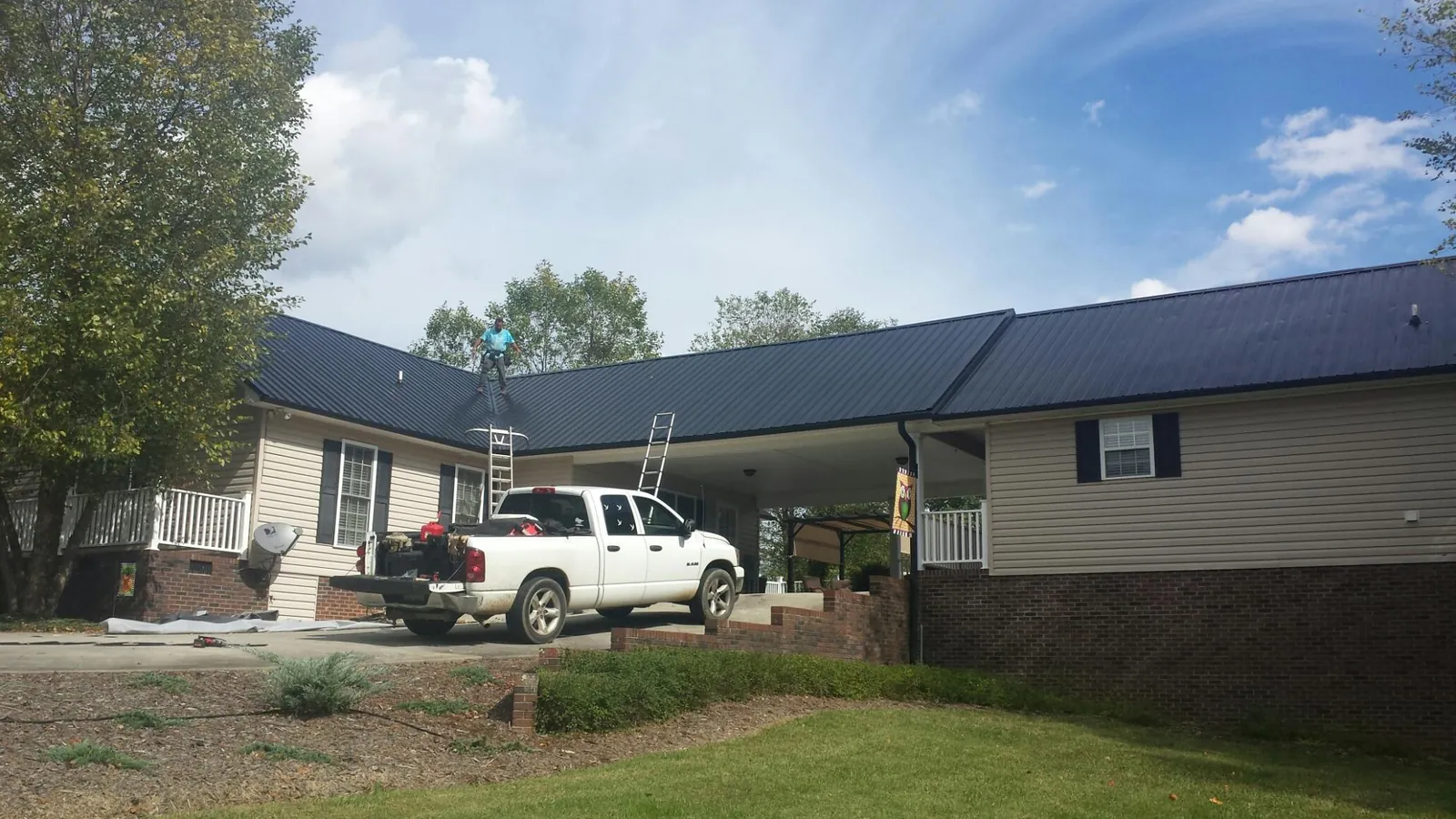 Black metal roof over a home and attached breezeway with ladders set in Somerset